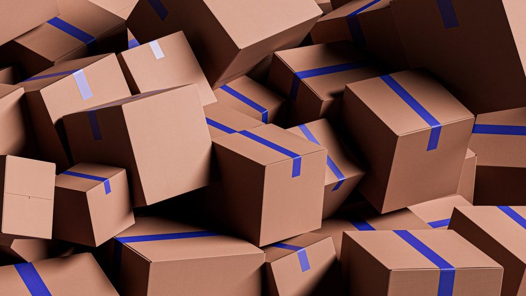A heap of plain cardboard boxes sealed with blue tape.